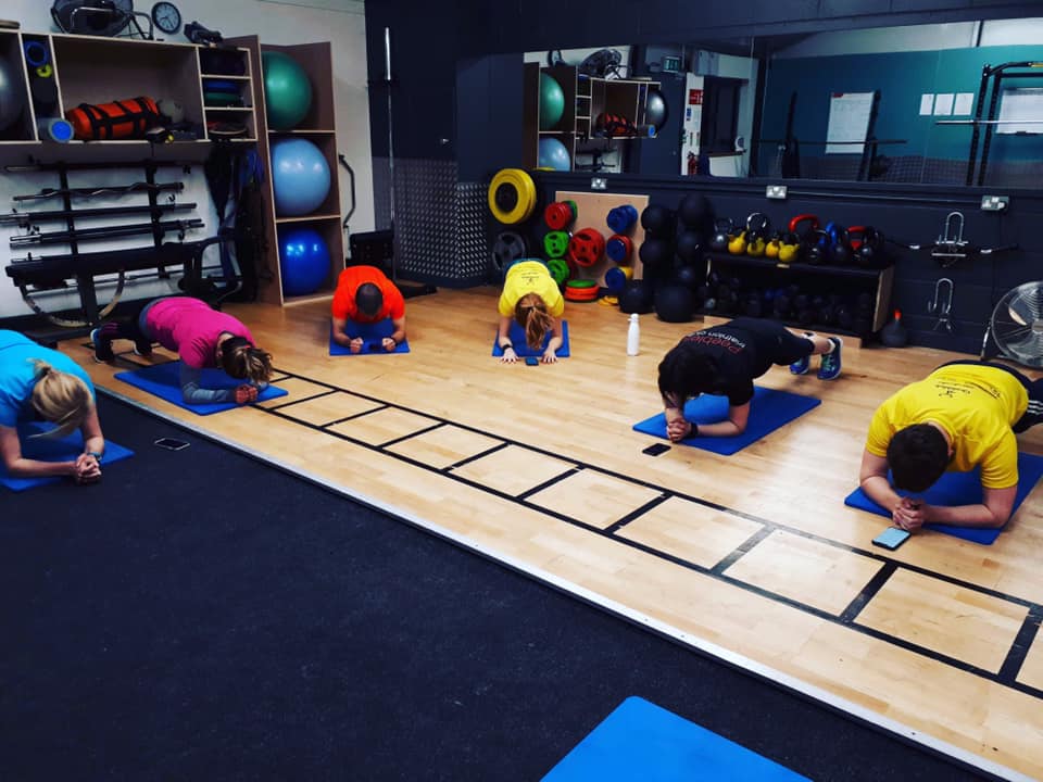 Group working doing planks