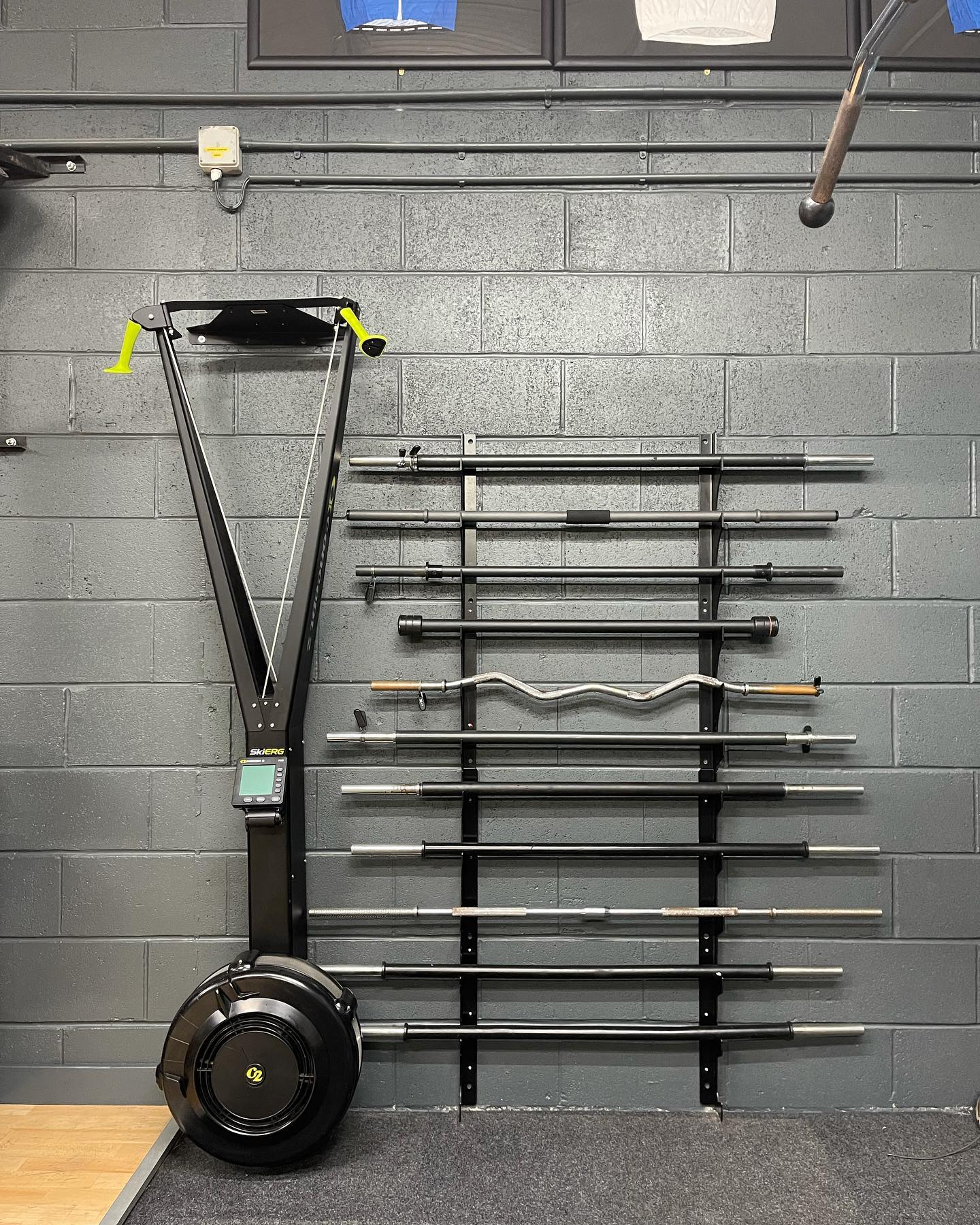 SkiErg machine and barbells on wall mount