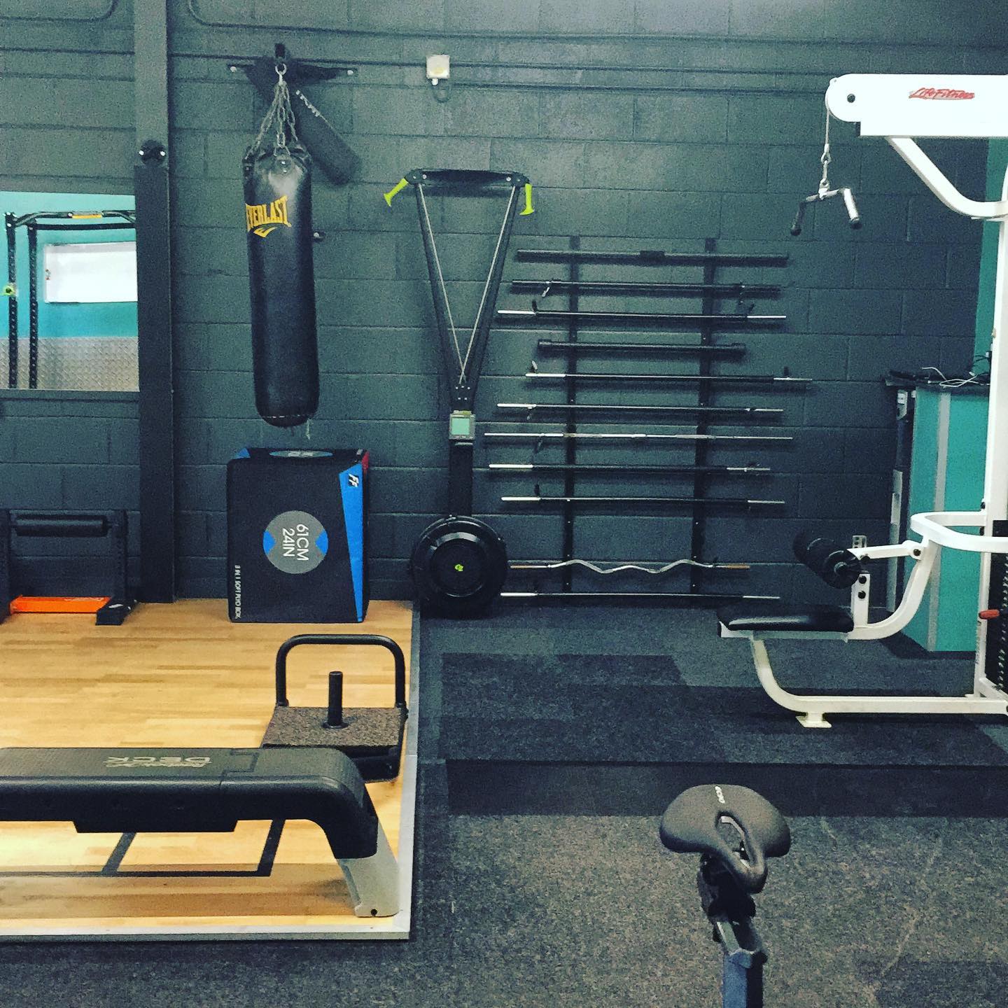 Gym floor with punching bag, barbells and pulldown cable machine